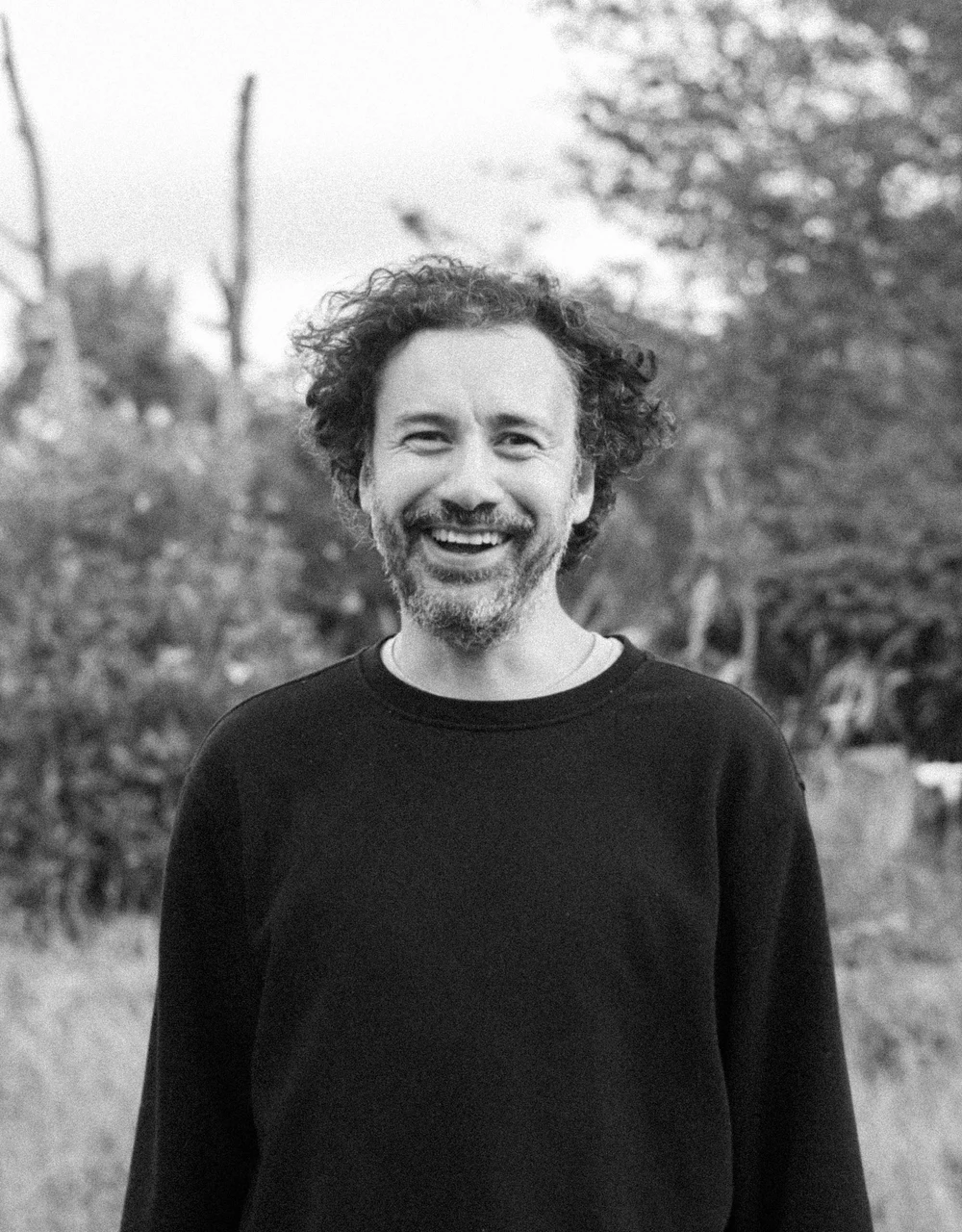 Black-and-white outdoor portrait of a smiling Coocine member