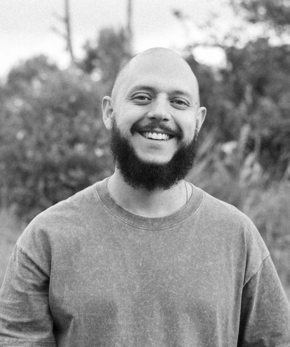 Black-and-white outdoor portrait of a Coocine member in a light pullover