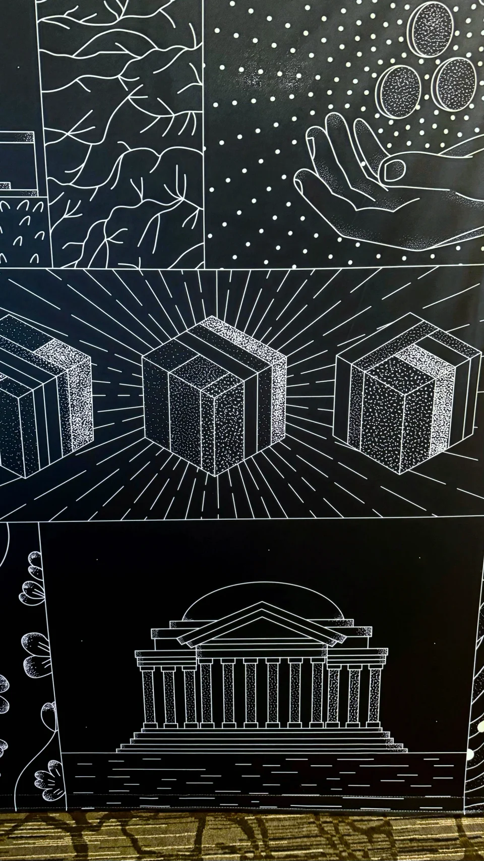 Detail of the printed Monetarium wall: hands, rayed cubes and the Jefferson Memorial